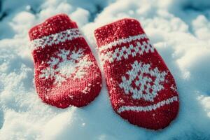 Cozy Red Knitted Mittens with Snowflake Pattern Resting on Fresh Snow in Winter Sunlight photo