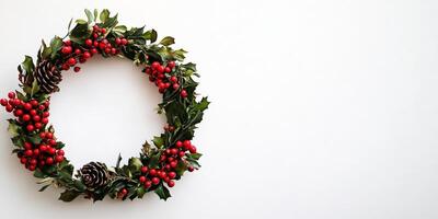 Wreath of red berries and pine cones is displayed on a white background photo