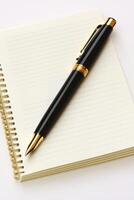 Elegant Black and Gold Pen on Open Lined Notebook for Writing and Office Use photo