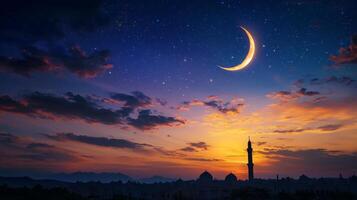 The crescent and moon are seen in the sky over a mosque photo
