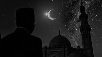 A man is silhouetted against the moon and crescent photo