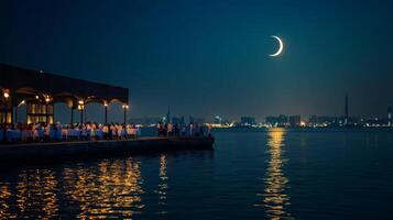 The moon is seen over the water in the night sky photo