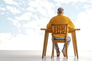 Contemplative Man at Desk Facing Bright Sky photo