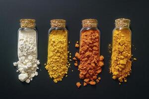 Colorful Powder Samples in Glass Jars on Dark Background photo