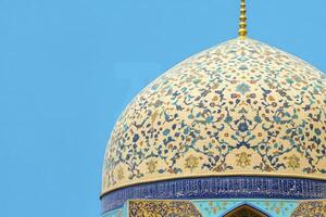 Ornate Dome with Intricate Mosaic Detail Against Blue Sky photo