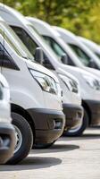 Row of White Vans Parked Outdoors on Sunny Day photo