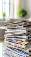Stack of Newspapers on Glass Table in Bright Room photo