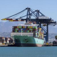 Teal Cargo Ship at Port with Industrial Cranes photo