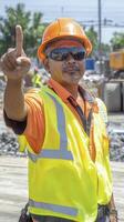 Construction Worker Signaling Outdoors in Bright Safety Gear photo