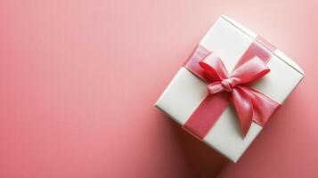 Elegant Gift Box with Pink Ribbon A Top-Down View Capturing the Essence of Celebration, Offering Versatile Visuals for Marketing Campaigns, Festive Greetings, and Special Occasion Announcements photo