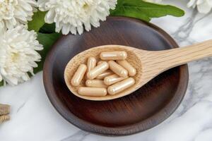 Elevate Your Wellness Journey with Natural Supplements A Captivating Image Showcasing Pills in a Wooden Spoon on a Rustic Plate, Accented by Fresh Flowers, Offering a Glimpse into Holistic Health and photo