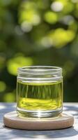 Golden Liquid in Glass Jar on Wooden Coaster A Vibrant Image Capturing Natural Light and Organic Essence This High-Resolution Stock Photo Depicts a Crystal-Clear Jar Filled with a Golden-Hued Liquid
