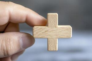 Wooden Plus Sign Held in Hand A Close-Up Shot for Concepts of Addition, Positivity, and Healthcare Discover the Symbolism Behind This Simple Shape and Its Representation in Math, Medicine, and photo