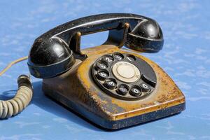 Vintage Rotary Dial Telephone on Blue Surface Nostalgia Calling, Featuring Classic Design and Antique Charm Explore the Beauty of Old Technology with this Retro Communication Device Perfect for photo
