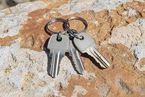 Unlock the potential with this captivating image of keys resting on a textured stone surface, perfect for symbolizing access, security, and new beginnings Ideal for real estate marketing, locksmith photo