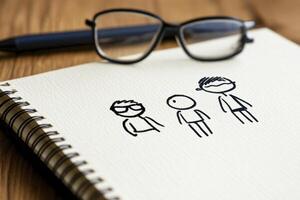 Unleash Your Creativity A Simple Sketch of Family Members on a Notepad, Accompanied by Glasses and a Pen Dive into the World of Doodle Art and Explore the Joy of Capturing Everyday Moments Through photo