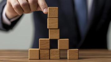 Strategic Planning and Business Growth A Conceptual Image of Wooden Blocks Stacked to Represent Building Success, Stability, and Progress, showcasing a Businessman's Hand Carefully Placing a Block photo