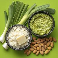 Explore the culinary possibilities with this vibrant image showcasing fresh leeks, homemade pesto, grated cheese, and crunchy almonds Discover the perfect combination of flavors and textures in this photo