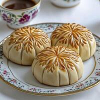 Delight in the Art of Pastry A close-up showcases the intricate details of three golden-brown pastries with meticulously designed leaf-like patterns, arranged on a delicate vintage plate photo