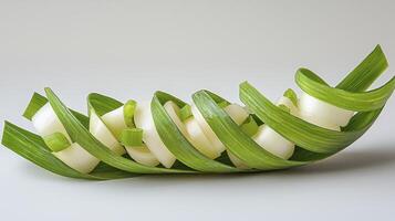 Discover the art of culinary presentation with this captivating image showcasing delicately sliced white food arranged within a vibrant green leaf cradle, a harmonious blend of nature and gastronomy photo