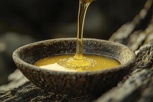 Golden liquid flowing into a rustic bowl, capturing the essence of nature sweetness This close-up showcases the textures of the bowl and the viscosity of the liquid Ideal for culinary projects photo