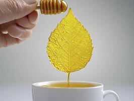 Captivating Honey Drip Photography Experience the Sweetness of Nature's Elixir, A Close-Up Shot of Golden Honey Flowing From a Honey Dipper Onto a Vibrant Yellow Leaf, Overflowing Into a White Teacup photo