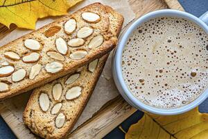 Capture the cozy autumn vibes with this stunning image showcasing biscotti and coffee alongside vibrant fall foliage, perfect for blogs, social media, and print materials Emphasize the warmth of the photo