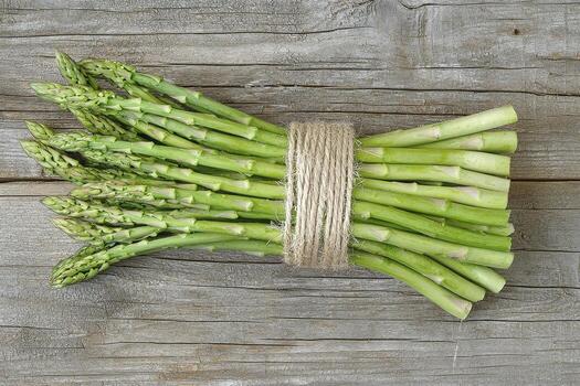 Fresh Green Asparagus Spears Tied with Rustic Twine on Weathered Wood Surface, Close-Up Still Life of Healthy Spring Vegetable, Nutrient-Rich Food Source for Diet and Wellness, Cooking Ingredient photo