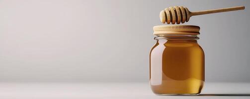 Golden Honey in Glass Jar with Wooden Dipper, a Sweet and Natural Delight Explore the richness of organic honey, perfect for breakfast, tea, or baking Indulge in this delicious treat and discover the photo