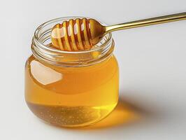 Golden Honey Jar with Dipper A Sweet Delight in Natural Light Capturing the Viscosity and Luminous Glow of Pure Honey, this Image Showcases a Glass Jar Filled with the Liquid Gold, Ready to Drizzle photo