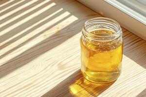 Golden Liquid in a Glass Jar A Captivating Still Life Photograph Bathed in Natural Light, Perfect for Illustrating Health, Wellness, and the Simplicity of Organic Living Capture the Warmth and Glow photo