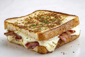 Indulge in the ultimate comfort food experience with this delectable grilled cheese sandwich, featuring crispy bacon strips and a generous helping of melted cheese oozing between two slices of photo