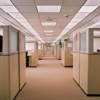 A seemingly endless corporate office unfolds before us, a symmetrical arrangement of cubicles stretching into the distance Each workspace, identical to the next, contributes to the overall sense of photo