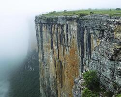 A breathtaking vista unfolds, showcasing nature's artistry at its finest Majestic canyon walls, weathered by time and the elements, stand as silent sentinels Ethereal fog, like a celestial veil photo