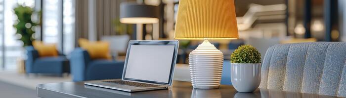 A contemporary workspace showcases a laptop with a pristine white screen, positioned beside a bright yellow lamp A decorative green plant adds a touch of nature to the scene, all set against a photo