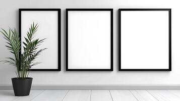 Three empty frames on a wall with a plant in a pot photo