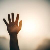 Outstretched hand reaching towards sunlight with bokeh effect symbolizing hope and new beginnings photo