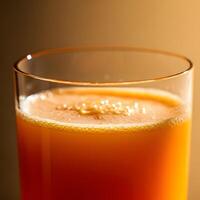 Close up of a foamy orange juice in a transparent glass with soft bokeh background and fresh citrus tones photo