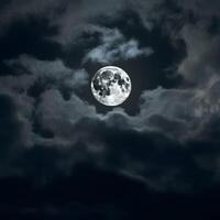 Bright full moon illuminating swirling dark clouds at night in a moody atmospheric sky photo
