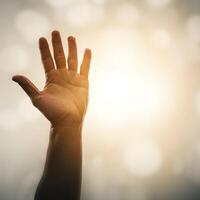 stretched hand reaching towards warm sunlight with bokeh effect symbolizing hope and new beginnings photo