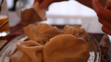 Close up of a chef delicately adding spices to a serving of khinkali, traditional georgian dumplings, arranged on a platter, enhancing their flavor video