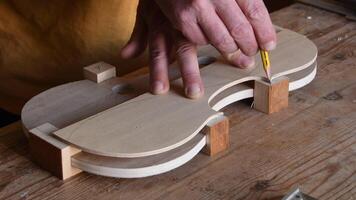 Luthier working in the structure of a new violin video
