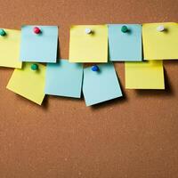 Blank cork bulletin board colorful sticky notes pinned in a row for reminders organization and office planning photo