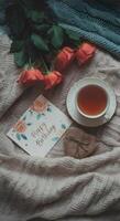 Romantic birthday tea setup with red roses handmade card and rustic wrapped gift on soft wool blanket photo