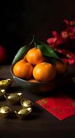 Fresh tangerines with green leaves in ceramic bowl golden ingots red envelope symbolizing prosperity luck Chinese New Year photo