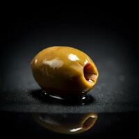Close up of single green olive with oil drop on dark textured background moody food photography macro shot gourmet photo