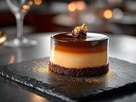 Elegant caramel chocolate mousse cake on slate with decorative gold finish photo