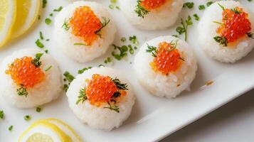 Elegant sushi balls with caviar and lemon garnish on white plate photo