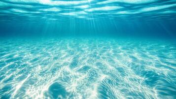 Sunlit underwater scene with rippling sand and clear blue water photo