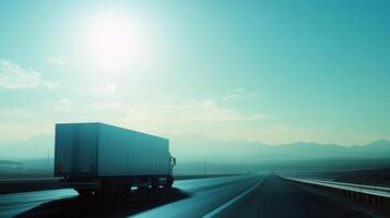 Semi-truck on desert highway at sunrise with mountains in background photo